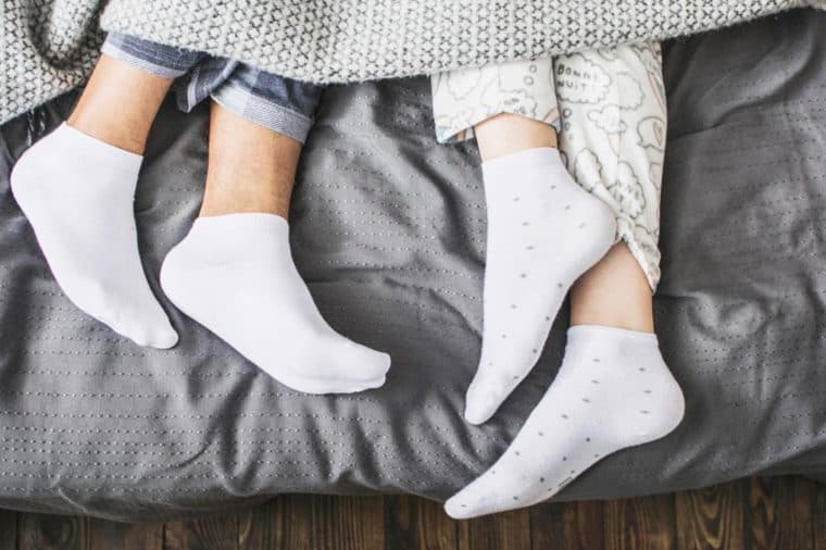 Tourist looking out of bedroom window next to suitcase